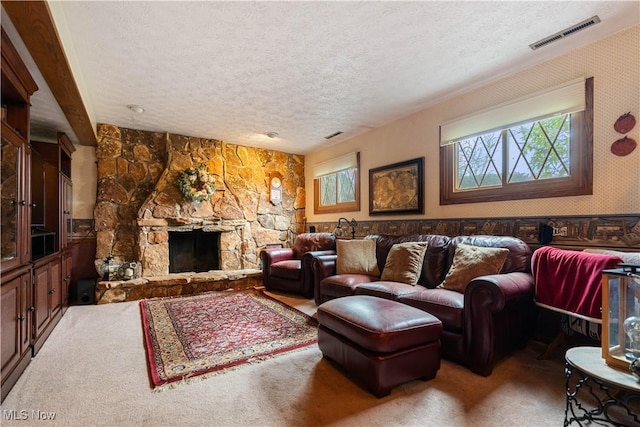 carpeted living room featuring a fireplace and a textured ceiling