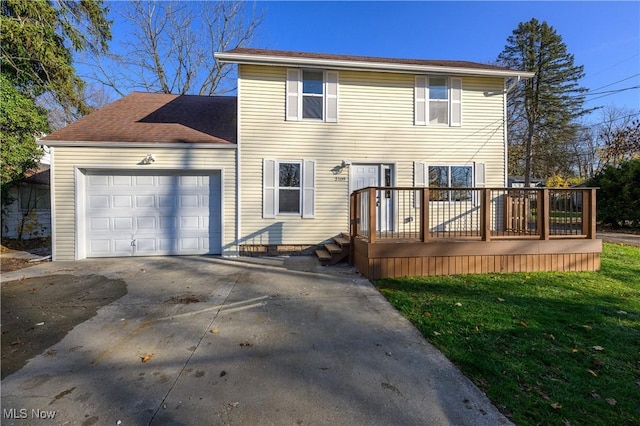 view of front of property with a deck, a front yard, and a garage