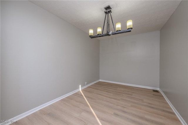 interior space with a chandelier, a textured ceiling, and hardwood / wood-style flooring