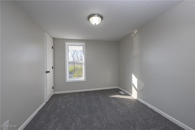 empty room with dark colored carpet