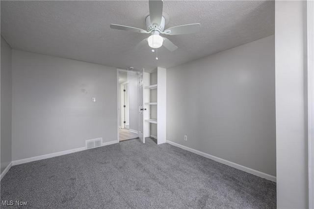 spare room featuring carpet flooring, ceiling fan, and a textured ceiling