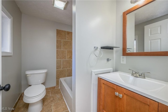 bathroom with vanity, a textured ceiling, and toilet