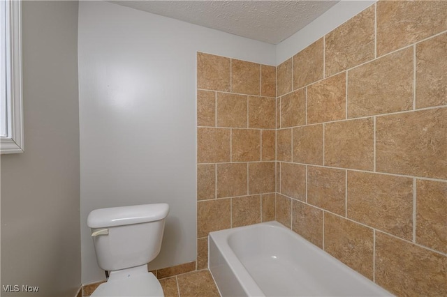 bathroom featuring tile patterned floors, a textured ceiling, and toilet