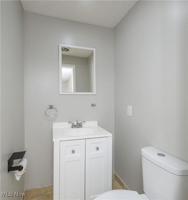 bathroom with tile patterned flooring, vanity, and toilet