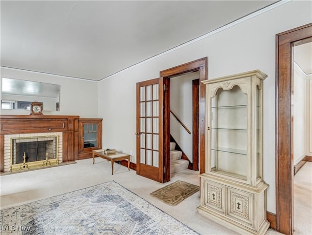 living room with light carpet, a fireplace, and french doors