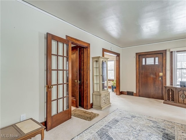 foyer entrance with carpet flooring and french doors