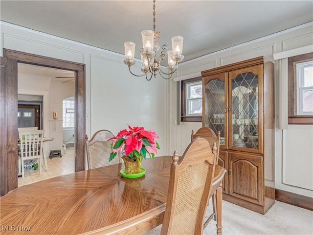 dining space with light colored carpet and a notable chandelier