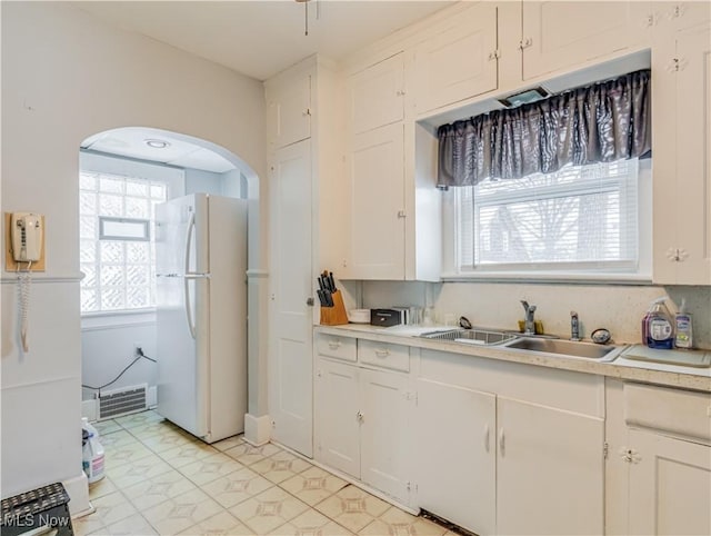 kitchen with white cabinets, white refrigerator, and sink