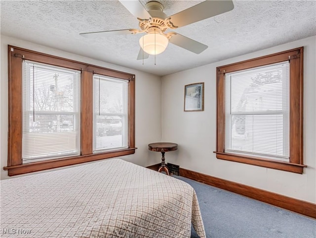 bedroom with a textured ceiling, carpet floors, and ceiling fan