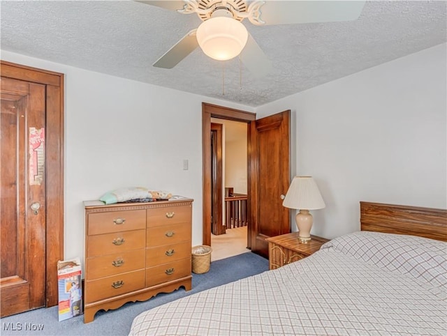 bedroom featuring carpet, ceiling fan, and a textured ceiling