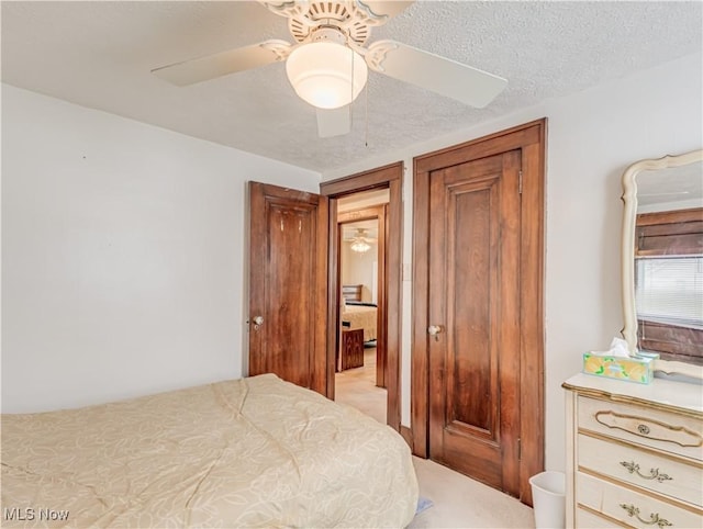 bedroom featuring ceiling fan and a textured ceiling