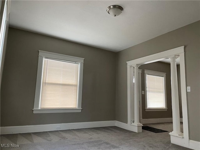 carpeted empty room with decorative columns