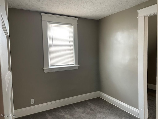 carpeted empty room featuring a textured ceiling