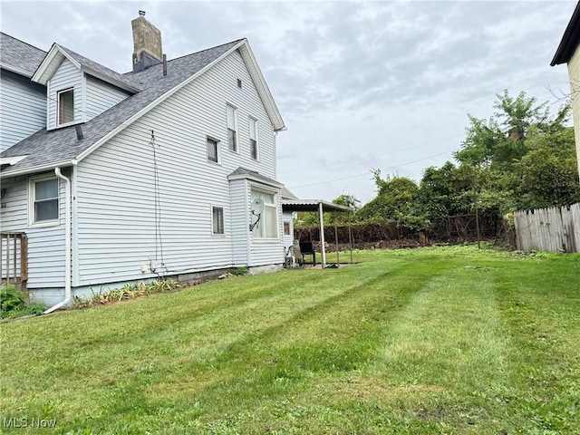 view of side of home with a yard