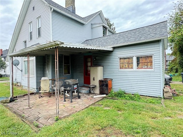 rear view of house featuring a yard and a patio area