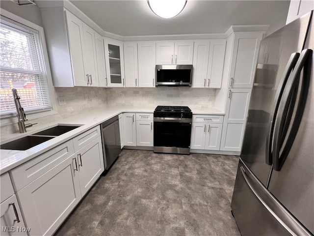 kitchen featuring white cabinets, appliances with stainless steel finishes, tasteful backsplash, and sink