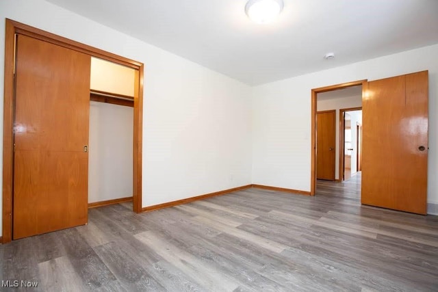 unfurnished bedroom featuring wood-type flooring and a closet