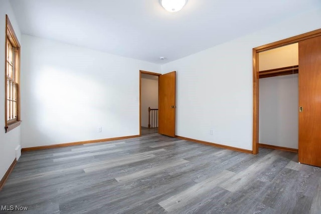 unfurnished bedroom with hardwood / wood-style flooring and a closet