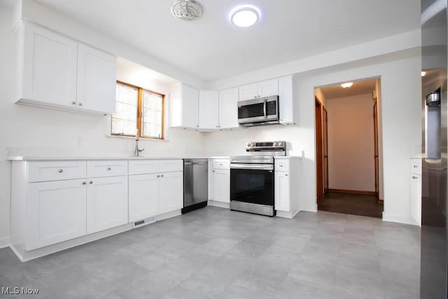 kitchen featuring white cabinets, sink, and appliances with stainless steel finishes