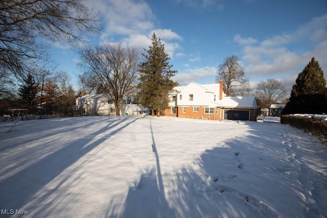 snowy yard with a garage