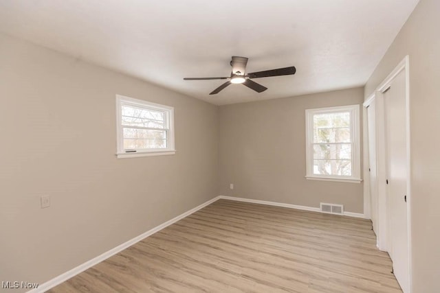 unfurnished bedroom featuring ceiling fan, light hardwood / wood-style floors, and multiple windows