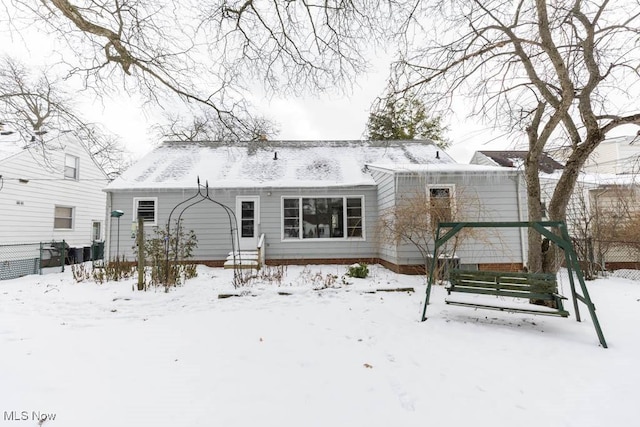 view of snow covered back of property