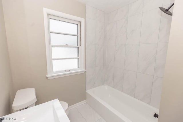 bathroom featuring toilet and tiled shower / bath