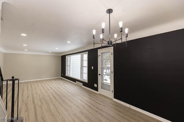 foyer entrance featuring crown molding, a chandelier, and light wood-type flooring