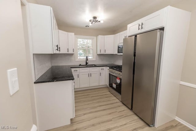 kitchen featuring tasteful backsplash, sink, white cabinets, and appliances with stainless steel finishes