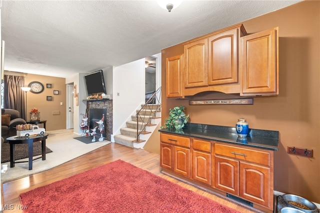 kitchen with light wood-type flooring and a textured ceiling