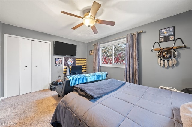 bedroom with ceiling fan, light colored carpet, and a closet