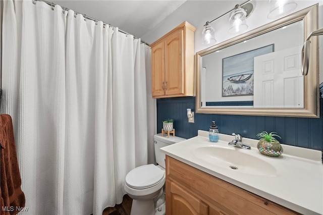 bathroom with a shower with shower curtain, vanity, and toilet