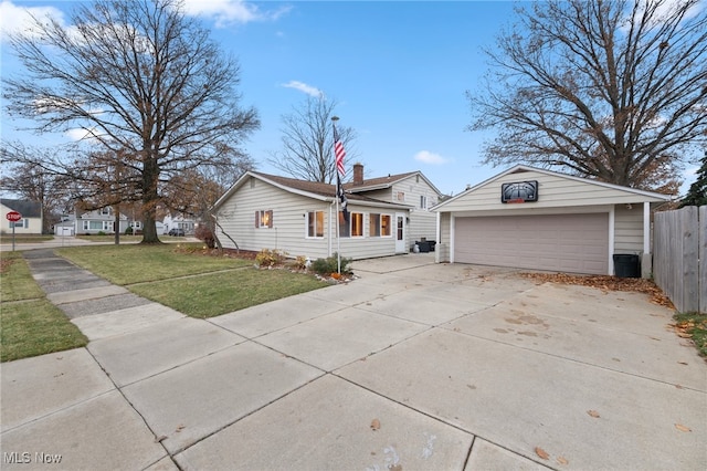 single story home featuring an outbuilding, a garage, and a front lawn