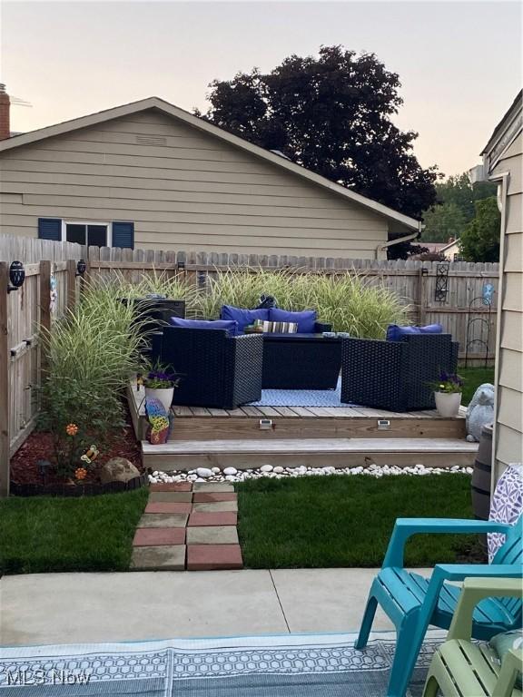 patio terrace at dusk featuring an outdoor hangout area and a deck