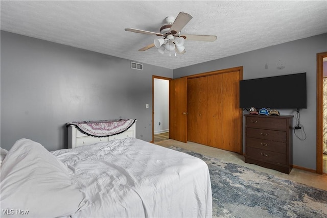 bedroom featuring ceiling fan, a closet, and a textured ceiling