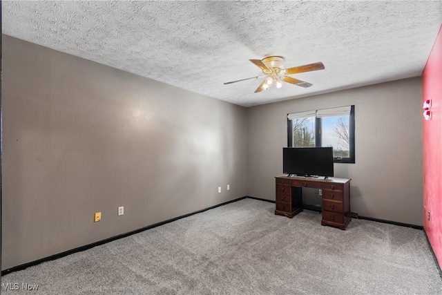 office area featuring light carpet, ceiling fan, and a textured ceiling