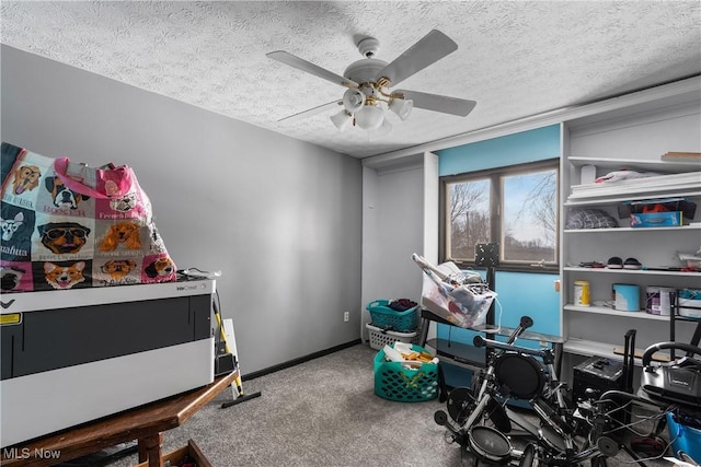 playroom featuring ceiling fan, carpet floors, and a textured ceiling