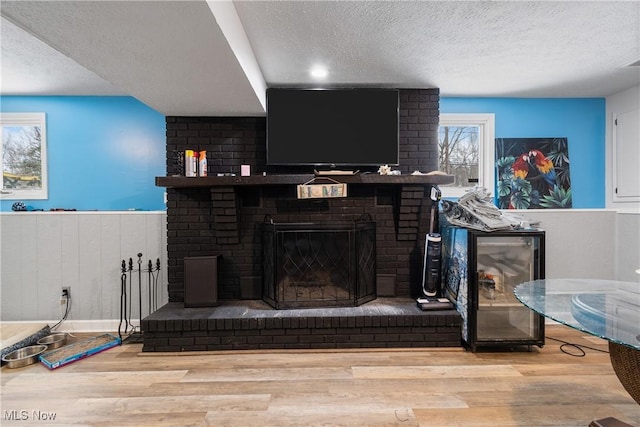 details with a textured ceiling, wood-type flooring, and a fireplace