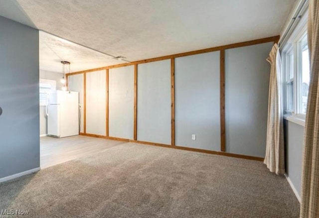 carpeted spare room featuring a textured ceiling