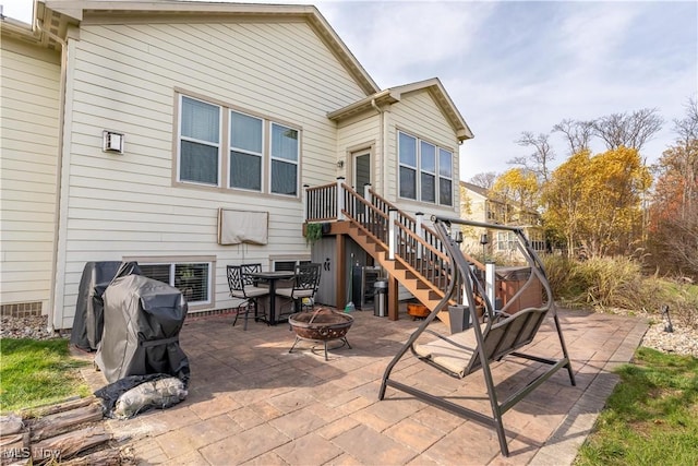 rear view of house featuring a fire pit and a patio