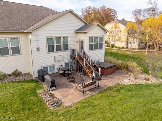 back of house featuring a patio area, a yard, and a hot tub