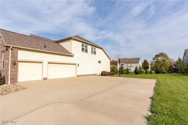 view of side of home featuring a garage and a yard