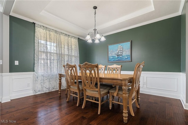 dining area featuring a tray ceiling, crown molding, dark hardwood / wood-style floors, and a notable chandelier