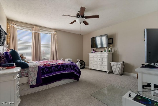 carpeted bedroom featuring ceiling fan and a textured ceiling