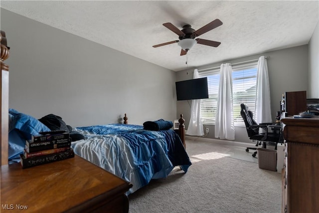 bedroom featuring ceiling fan, light carpet, and a textured ceiling