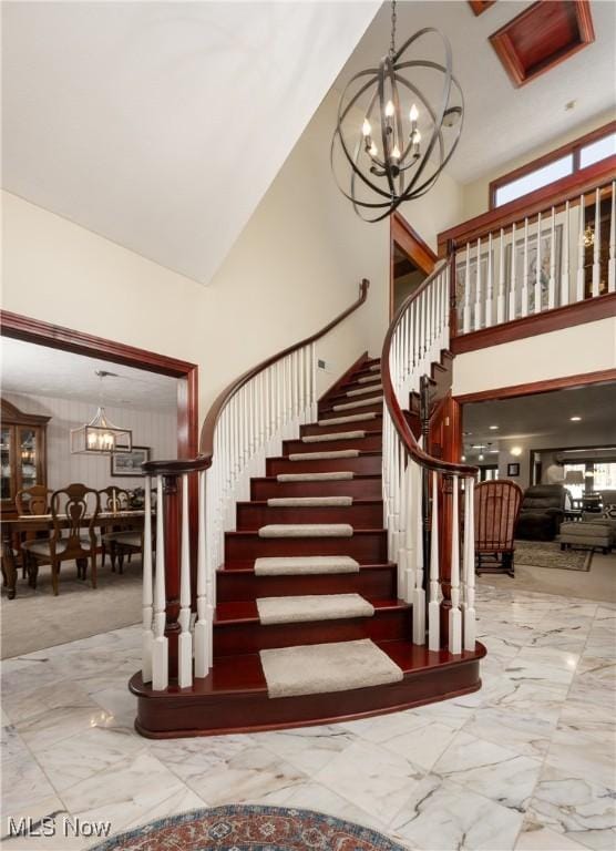 stairway with a high ceiling and an inviting chandelier