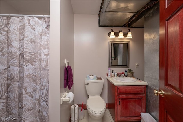 bathroom with tile patterned floors, vanity, toilet, and curtained shower