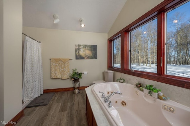 bathroom featuring tiled bath, vaulted ceiling, and hardwood / wood-style flooring