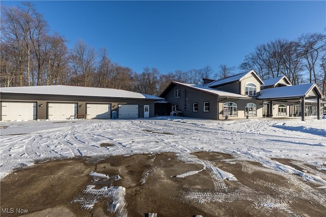 snow covered property featuring a garage