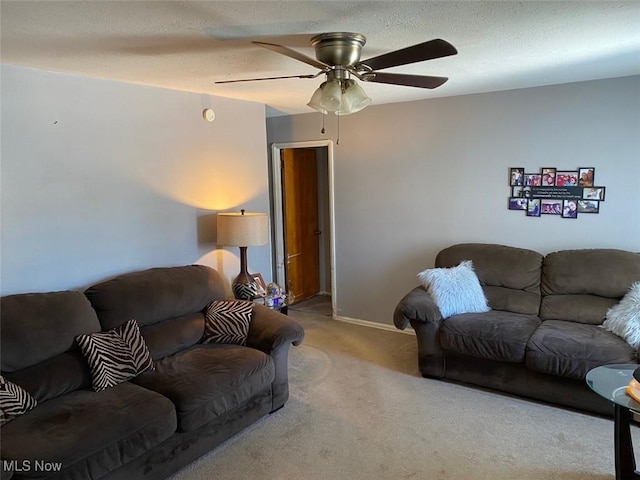 carpeted living room with a textured ceiling and ceiling fan